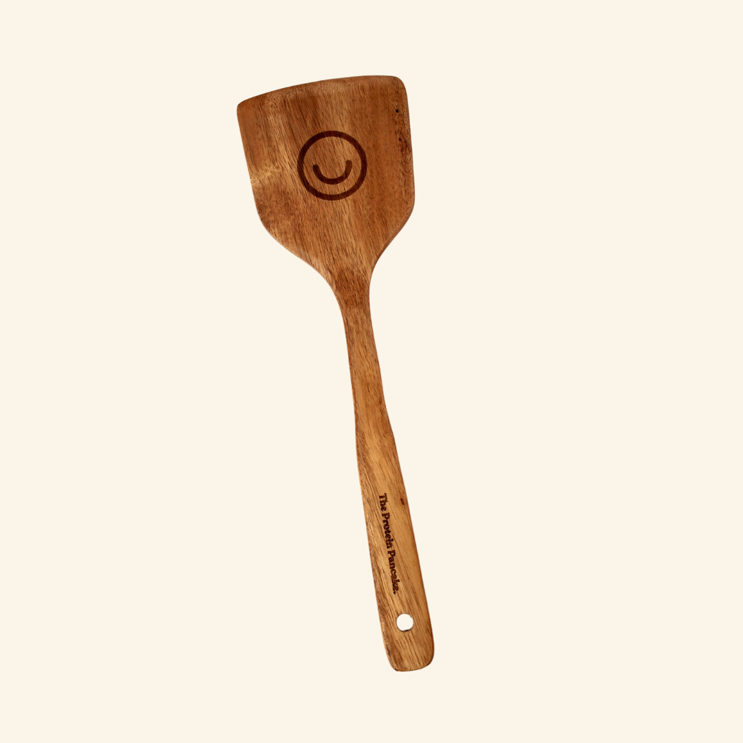 Wooden spatula with handle engraving and circular design on the head.